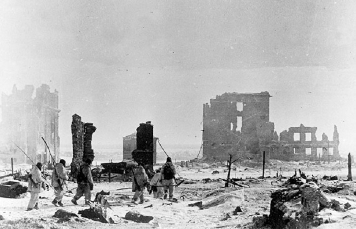 Группа советских саперов со щупами направляется на разминирование в центре разрушенного Сталинграда.