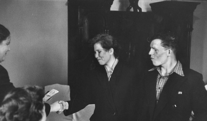 Молодая пара получающая от работника ЗАГСа сертификат после завершения гражданской церемонии бракосочетания. СССР, 1958 год.