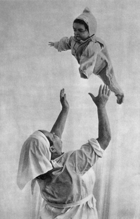  Женщина подбрасывает вверх ребенка. Фотограф Александр Птицын, 1970 год.