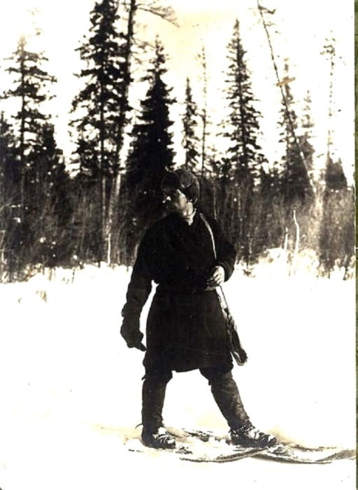 Охотник стоит на широких коротких лыжах, крепящихся к ступне ремешками.