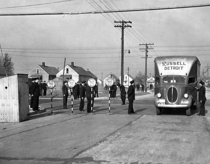 Более 1500 военных и полицейских города и штата охраняют перевозимых в автофургонах работников. Детройт, 29 апреля 1942 года. 