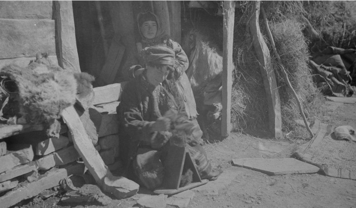 Старая хевсурка прядет шерсть возле дома. 1929 год. 