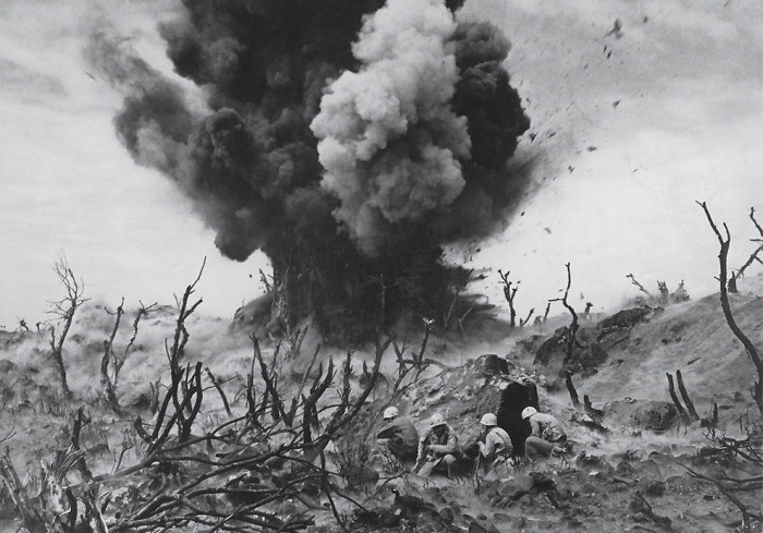Морские пехотинцы укрываются от огня на вершине холма на Иводзиме в марте 1945 года.