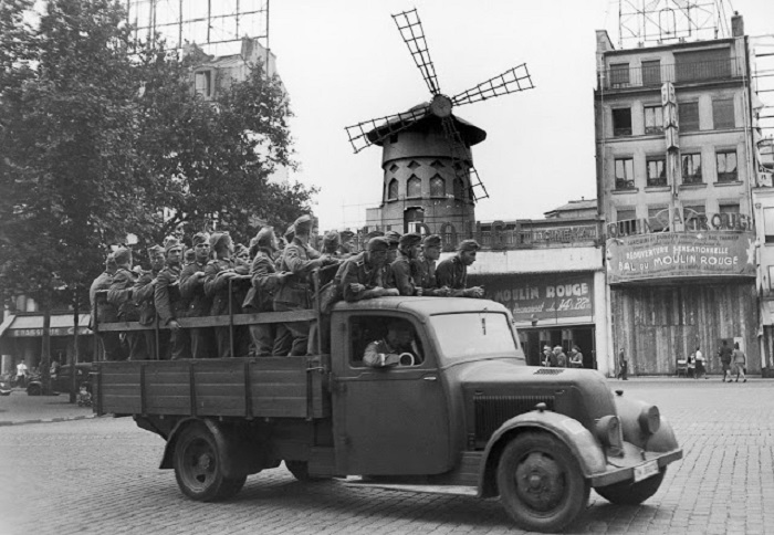 Немецкие солдаты, оккупировавшие Париж, проезжают мимо «Мулен Руж».