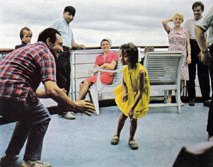 На палубе теплохода один из гидов учит девочку танцевать твист. СССР, 1970 год.