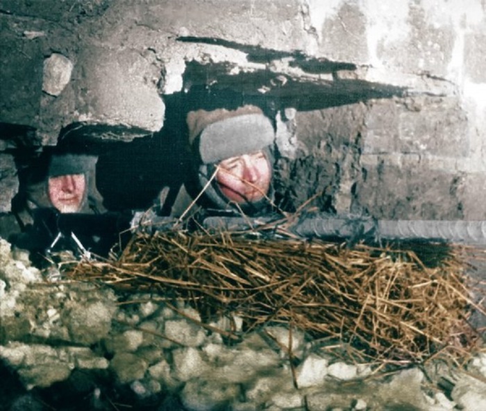 Два советских солдата с противотанковой пушкой, замаскированные в разрушенном здании в Сталинграде.