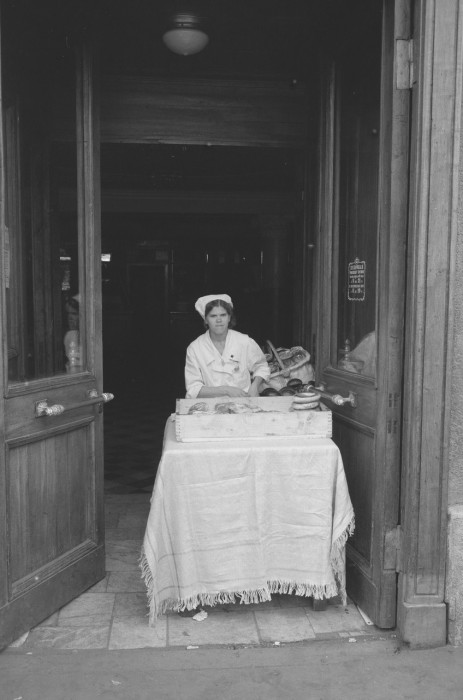 Женщина, продающая пекарские изделия у входа в здание. СССР, Москва, 1961 год.