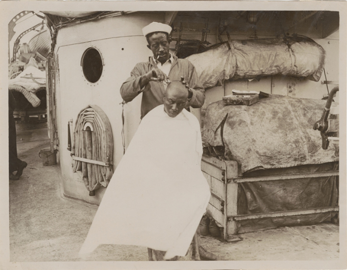 Афроамериканец бреет голову товарищу. Фотография начала XX века. 