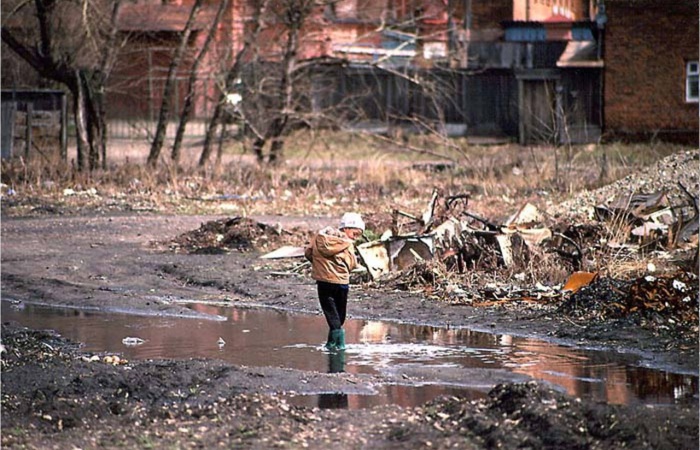 Ребенок, стоящий в луже во дворе домов между улицами Фурье и Чехова. СССР, Иркутск, 1988 год.