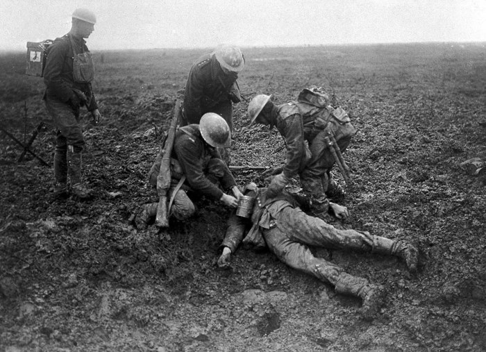 Канадские солдаты досматривают убитого немецкого солдата.