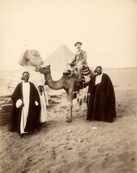 Турист и гиды с верблюдом.