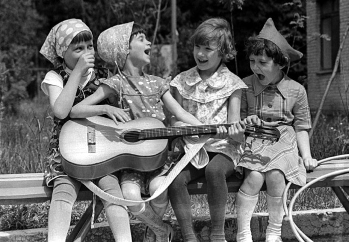 Девочки, играющие на гитаре в школьном дворе. 