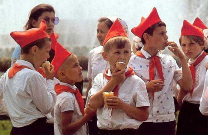 Дети кушают мороженное на территории пионерского лагеря. 