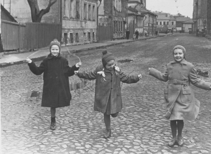 Девочки, прыгающие на скакалке на одной из улиц. 