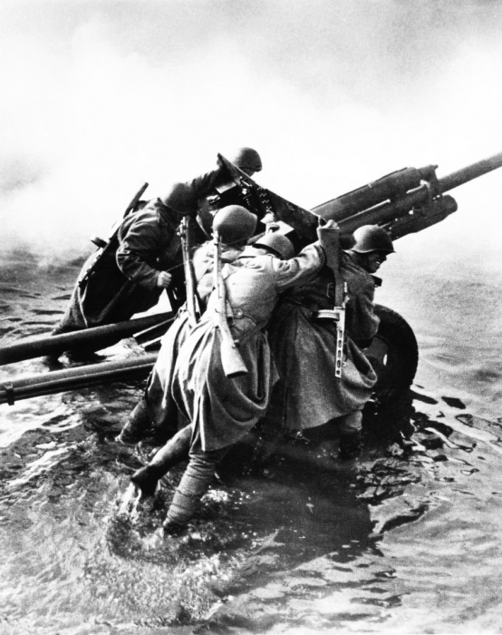 Советские артиллеристы транспортируют 76-мм дивизионную пушку ЗиС-3 во время форсирования Одера.