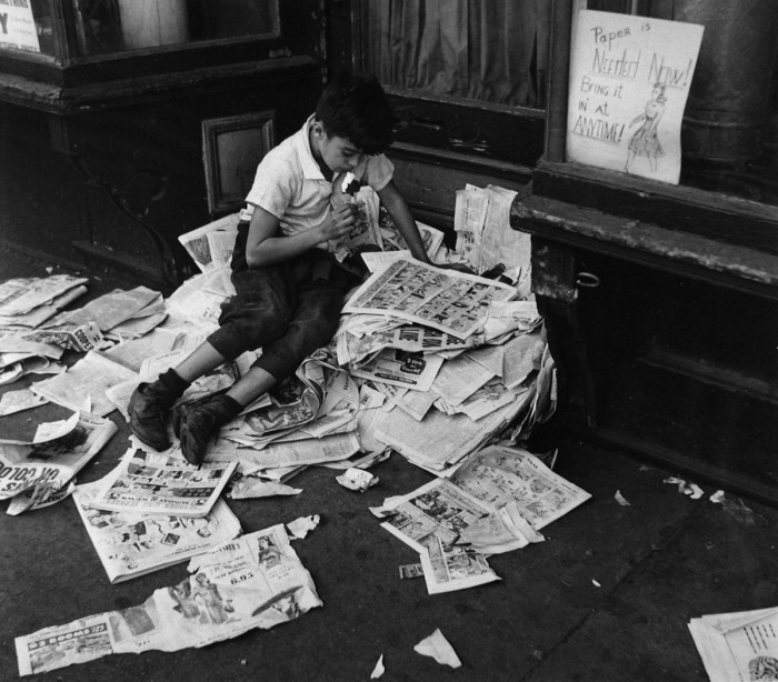 Мальчик с мороженым читает газету. США, Нью-Йорк, 1944 год.