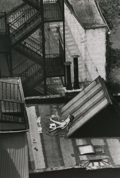 Девушка загорает на крыше дома в солнечный день. США, Нью-Йорк, 1978 год.