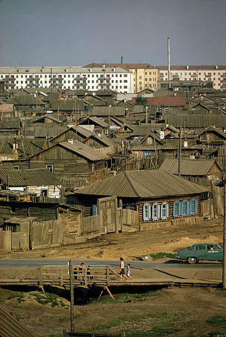 Новые многоквартирные дома возвышаются над старыми избами в Якутске.