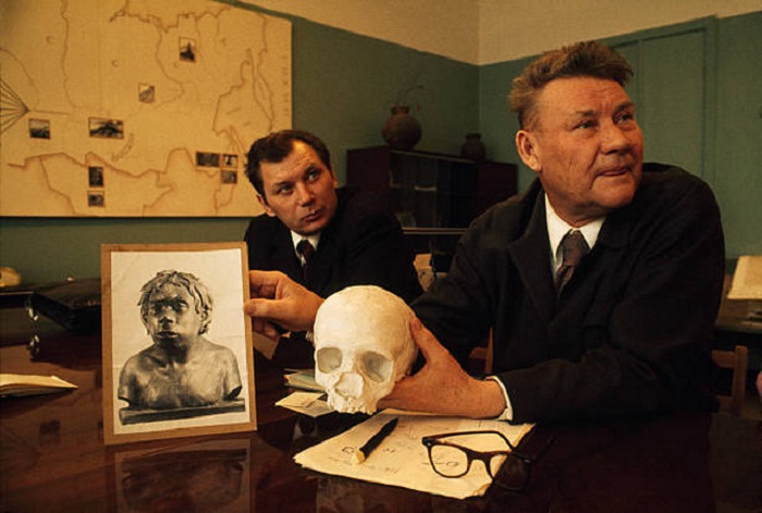 Академик А. П. Окладников с черепом и реконструкцией неандертальца, жившего в Узбекистане 40000 лет назад.