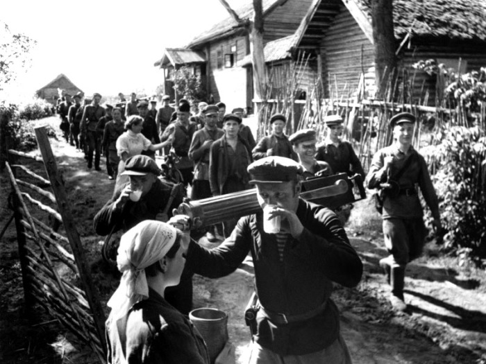 Местные жители встречают партизан, освободивших деревню.