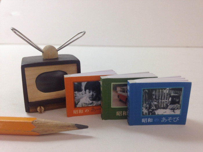 Три японские книги с чехлом в форме телевизора, через экран которого видна картинка с обложки.