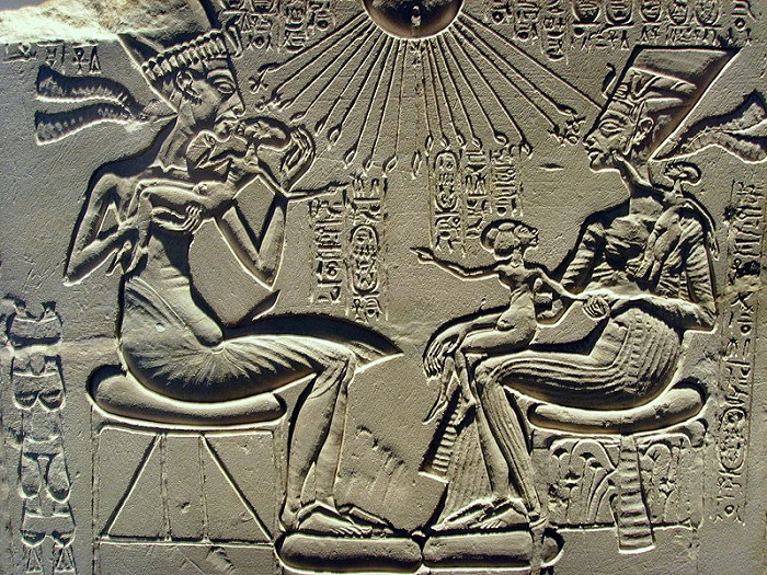 Эхнатон целует старшую дочь Меритатон, её сестра Макетатон сидит на коленях Нефертити, а младшая Анхесенпаатон играет с серьгами матери.