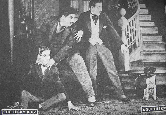1921 год – первое совместное появление Лорела и Харди в фильме «Счастливый пес» (Lucky Dog). Харли за шею усаживает Лорела на пол...