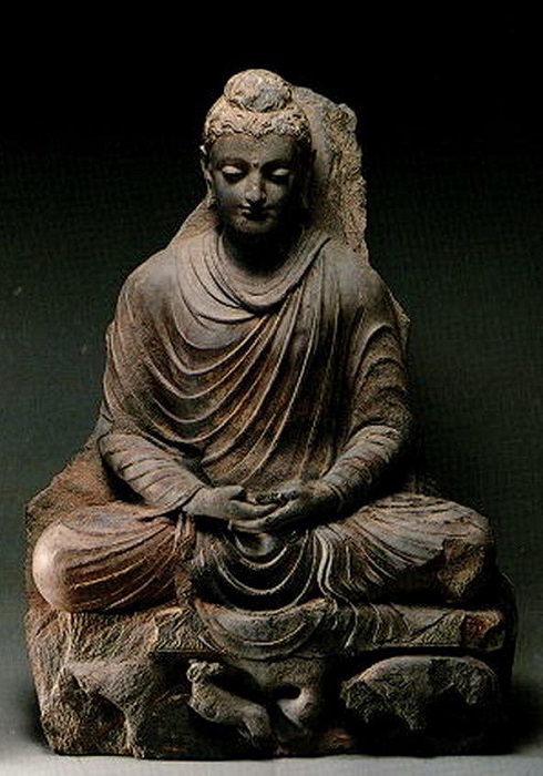 Сидящий Будда. Индийский скульптор уходит от традиций гиперреализма, убирая излишние приметы мужественности Будды и делая его почти бесполым на вид, что подчёркивает его отрешённость от земных страстей.