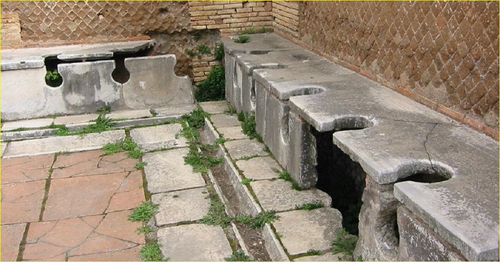 Общественные туалеты Древнего Рима были не для интровертов. Обратите внимание на отверстие под сиденьем - именно через него, с помощью насаженной на палку губки, специальный раб помогал клиентам навести чистоту.