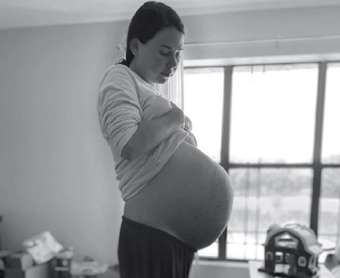 Молодая женщина с благодарностью и счастьем вспоминает свою многоплодную беременность. 