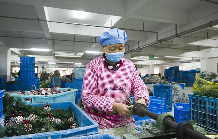 Работница китайского предприятия в Иу собирает искусственную ёлку. 