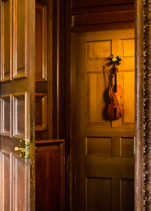 Изображенная на двери скрипка в поместье Чатсуорт-хаус, Дербишир, Англия