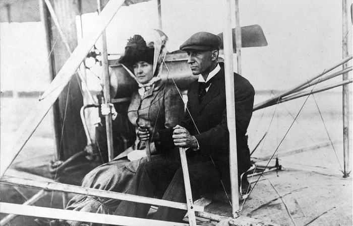 Эдит Берг в юбке, перевязаннои&#774; веревкой, с Уилбором Раи&#774;том на аэроплане. Сентябрь 1908 года