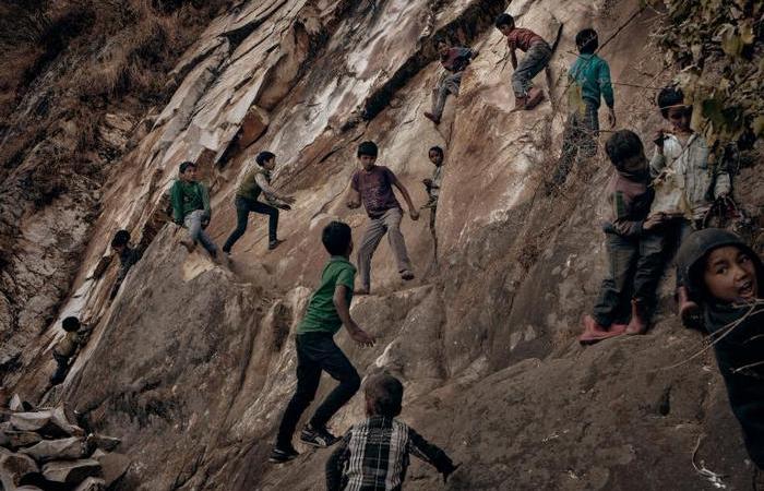 Деревенские детки, играющие на крутой горе на окраине деревни. Традиционно в местных семьях много детей.