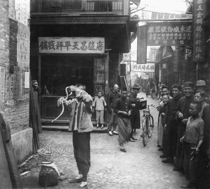 Заклинатель змей на шанхайской улочке.