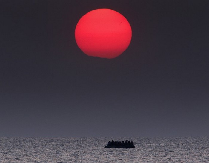 Переполненная надувная лодка с сирийскими беженцами дрейфует в Эгейском море между Турцией и Грецией после поломки мотора возле греческого острова Кос. (Thomson Reuters / Яннис Бехракис - 11 августа 2015)