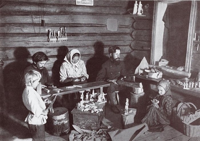 Семья за изготовлением деревянных игрушек.
