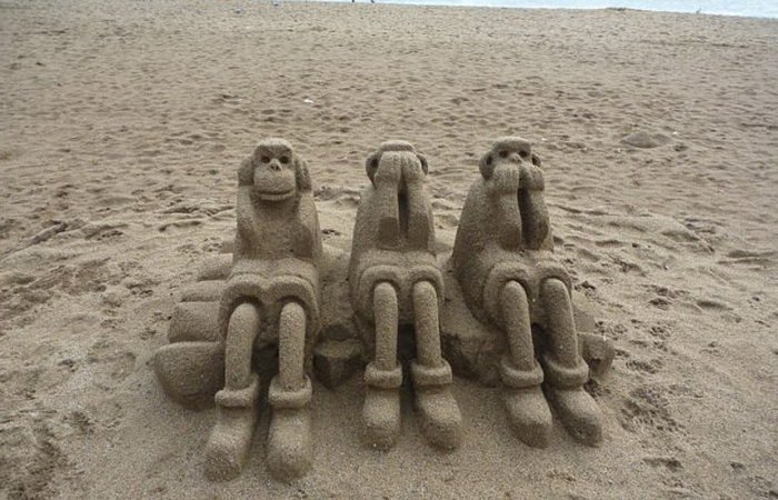 Три мудрые обезьяны на пляже в Барселоне.