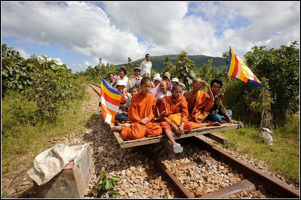 Туристический поезд из бамбука везет крестьян и буддийских монахов